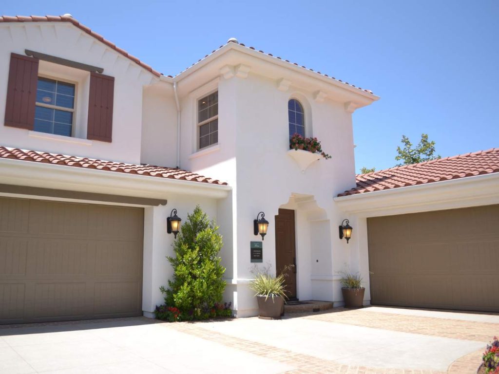 A home with various affordable exterior improvements like new paint, landscaping, and updated lighting